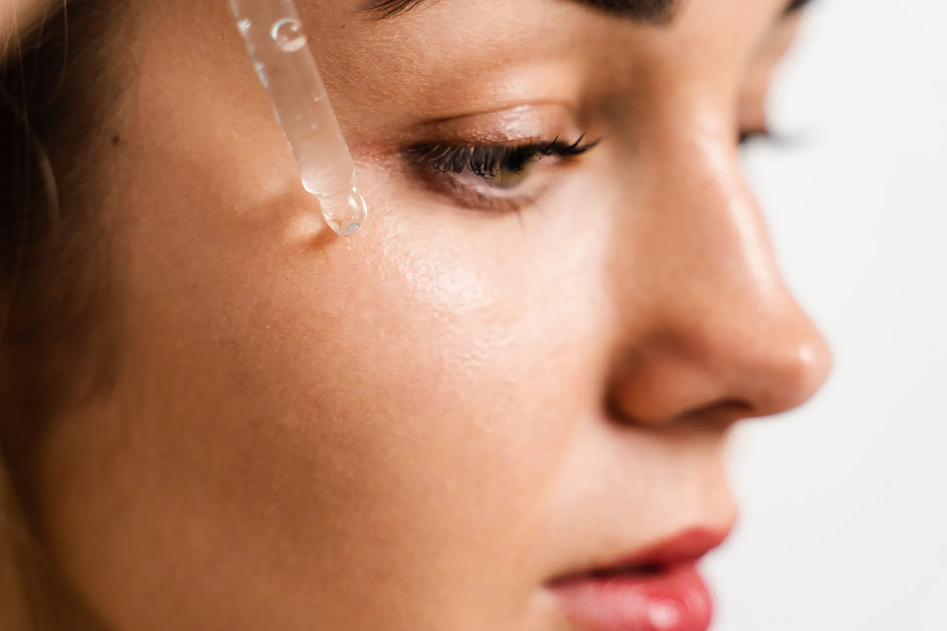 Hyaluron-Serum wird mit einer Pipette auf die Haut unter dem Auge aufgetragen