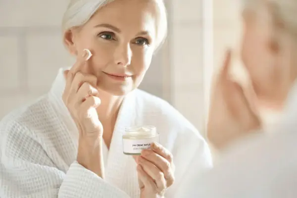 Reife Frau trägt 24h Creme natur auf – Anti-Aging ohne Botox Hautpflege